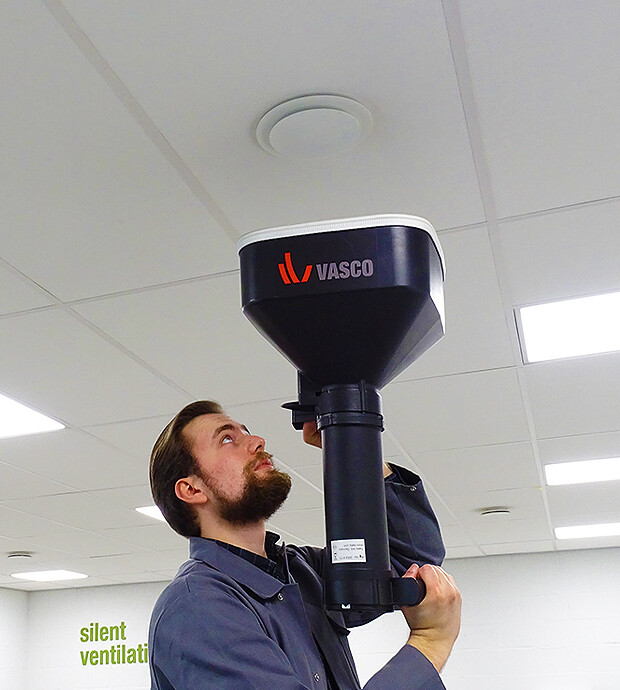 Installateur meet het debiet van een ventilatie ventiel in het plafond. Vasco ventilatie opstartservice.
